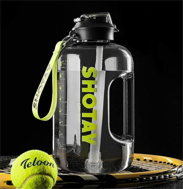 Large water bottle with 'SHOTAY' branding on a black background, next to a tennis ball and racket.