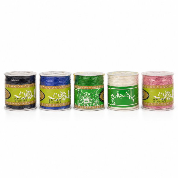 Five spools of embroidery thread in different colors (black, blue, green, white, and pink) lined up on a white background. Each spool has a green and gold label with the brand name 'SHIYAN'.