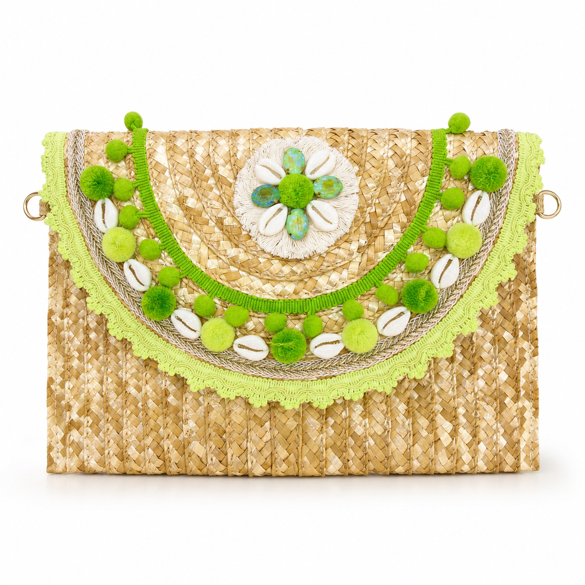 A woven straw clutch bag with a green embroidered semicircle trim, green pom-poms, cowrie shells, and a central flower motif on a white background.