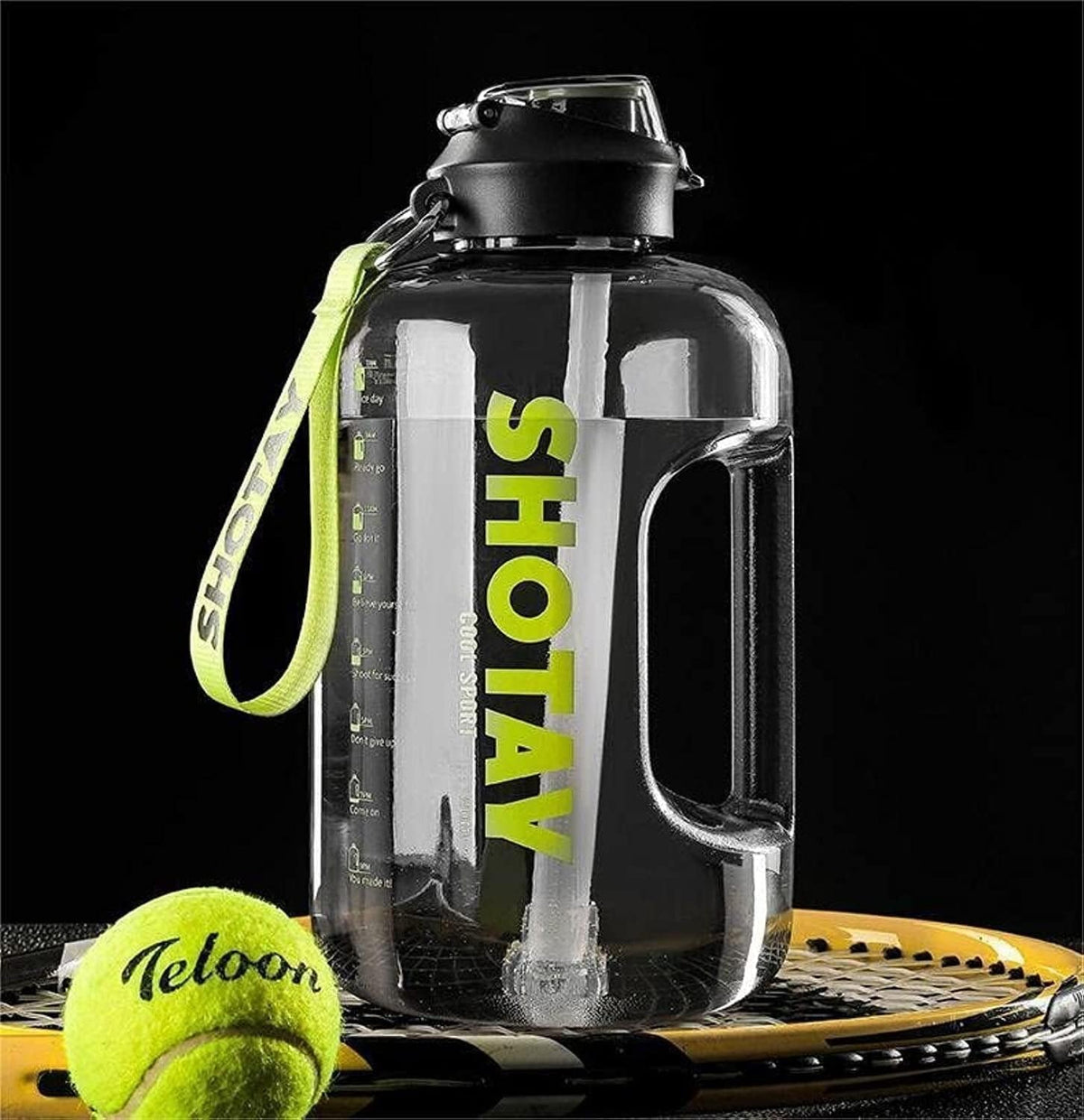 Large water bottle with 'SHOTAY' branding on a black background, next to a tennis ball and racket.