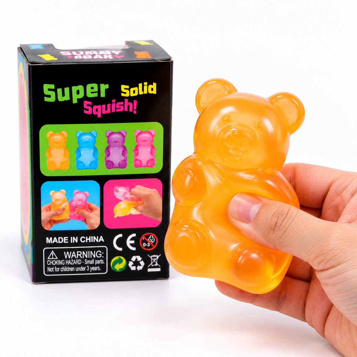 A hand holding a translucent orange bear-shaped squishy toy next to its black retail box labeled 'Super Solid Squishy' on a white background.