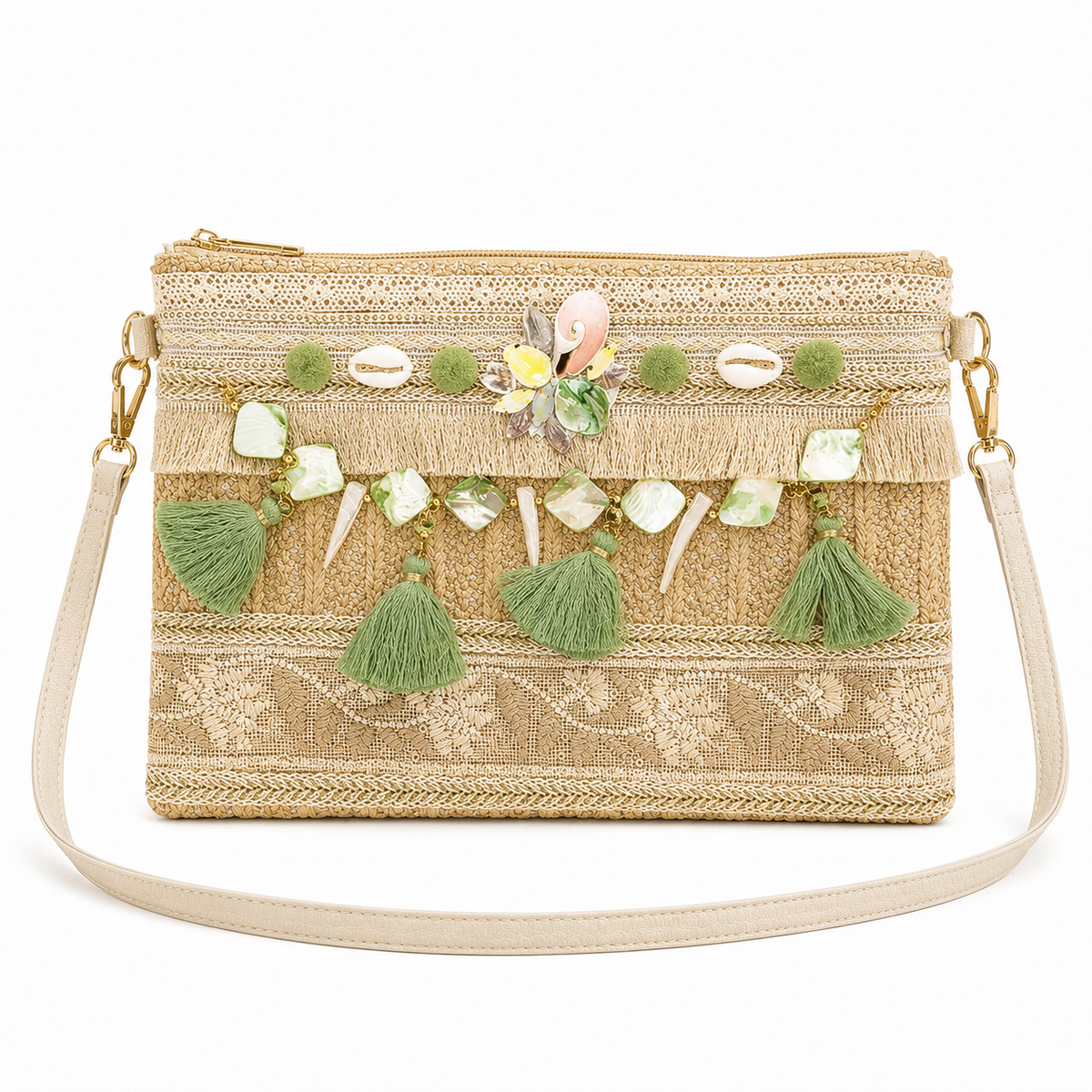 A woven straw clutch bag with a gold zipper, decorated with green tassels, cowrie shells, and a central floral embellishment, shown on a white background.