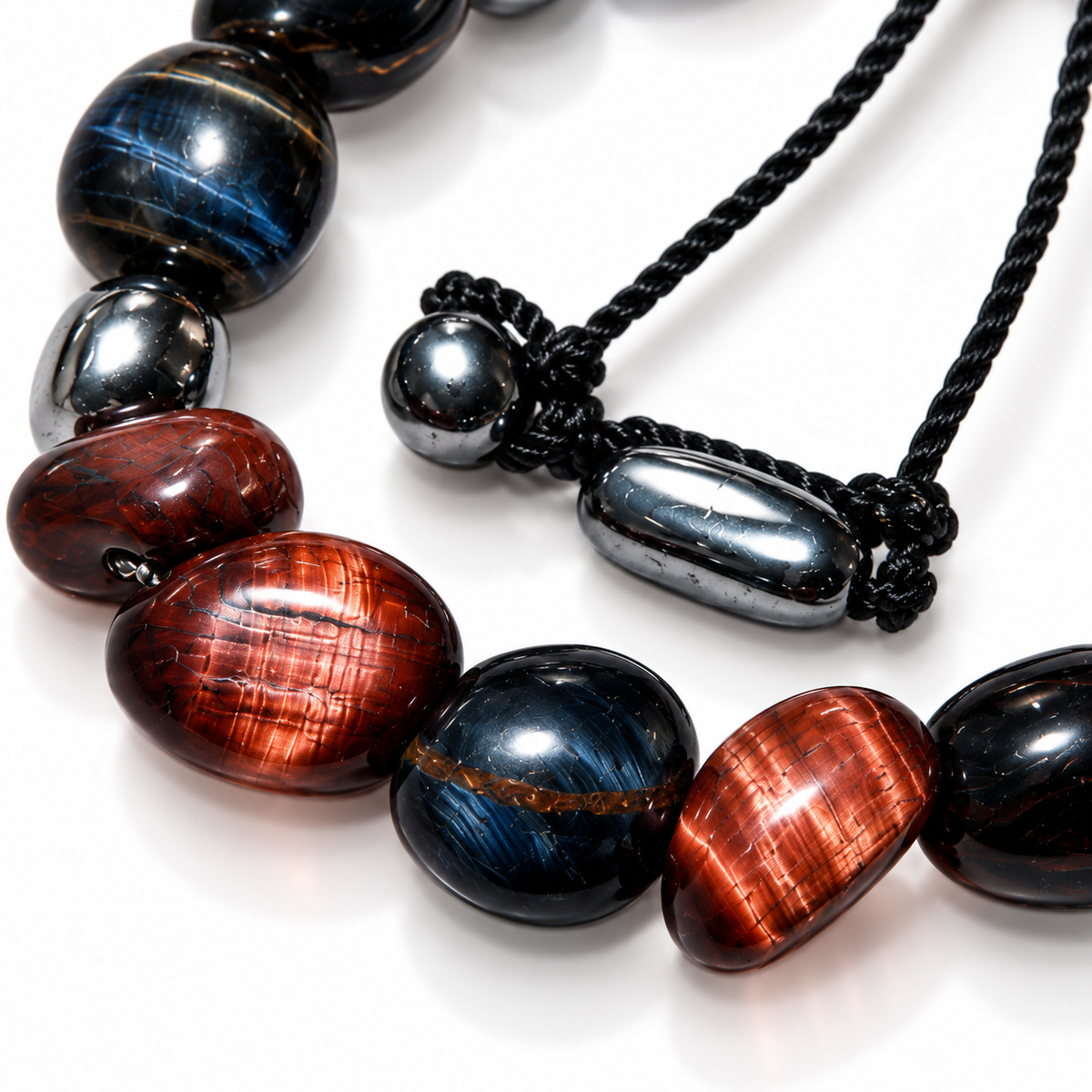 7agat close-up of reddish-brown Tiger Eye beads, dark Hawk's Eye gemstones and silver-tone hematite spacers