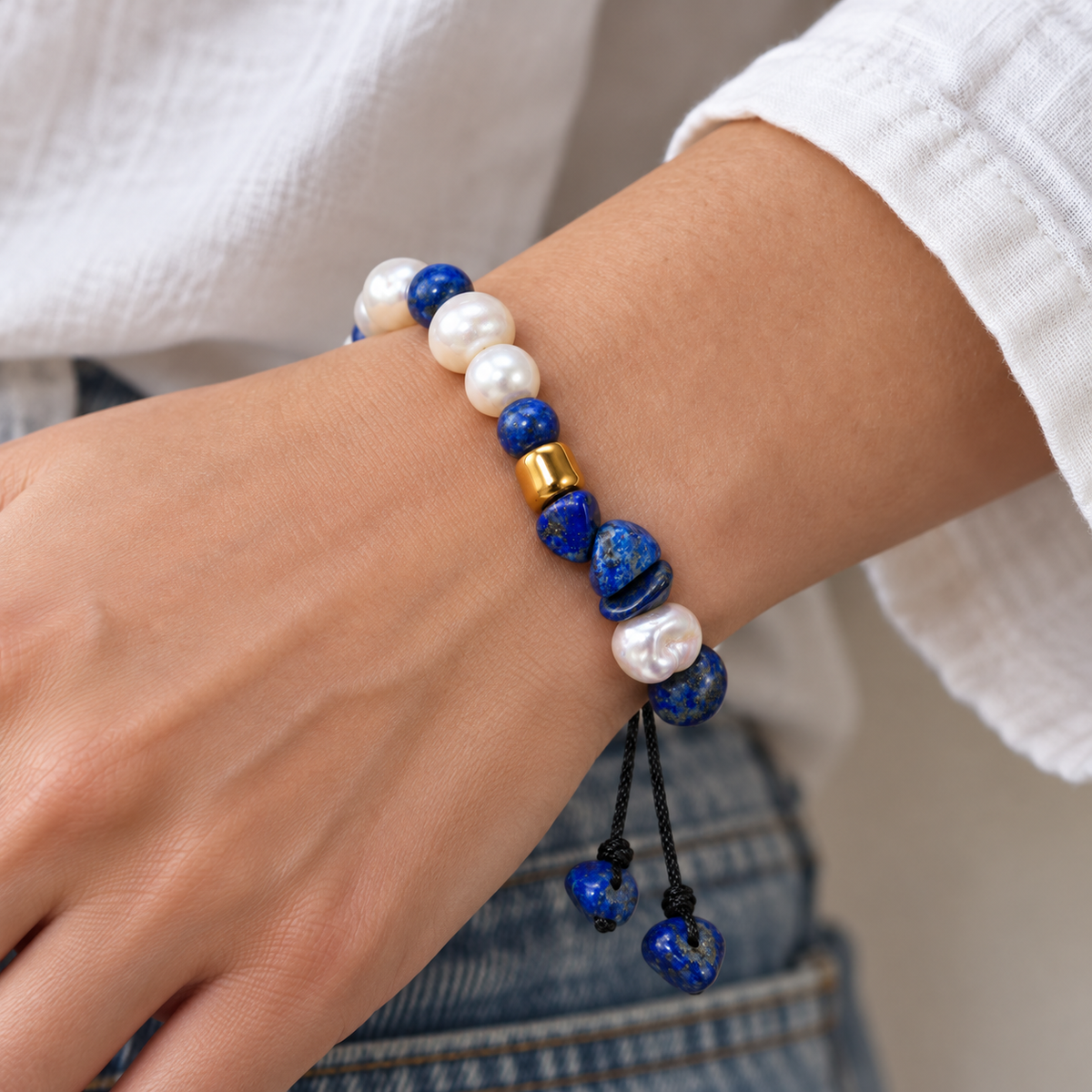 7agat_white_cultured_pearl_and_lapis_lazuli_adjustable_bracelet_worn_on_a_wrist_with_neutral_clothing