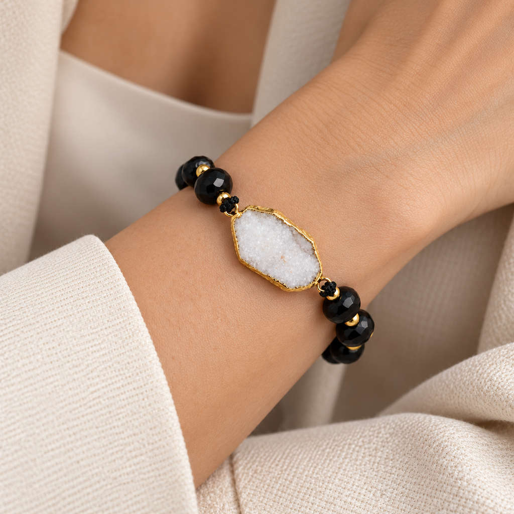 7agat black Onyx bracelet with White Quartz Agate centerpiece styled on a woman's wrist.