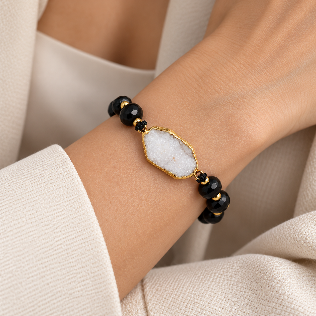 7agat black Onyx bracelet with White Quartz Agate centerpiece styled on a woman's wrist.