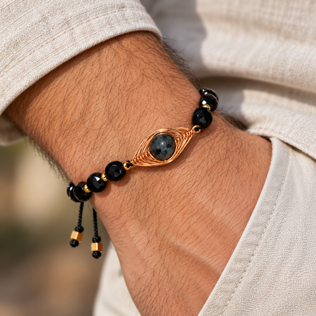 7agat faceted black Onyx bracelet with gold Hematite and copper centerpiece on a man's wrist.