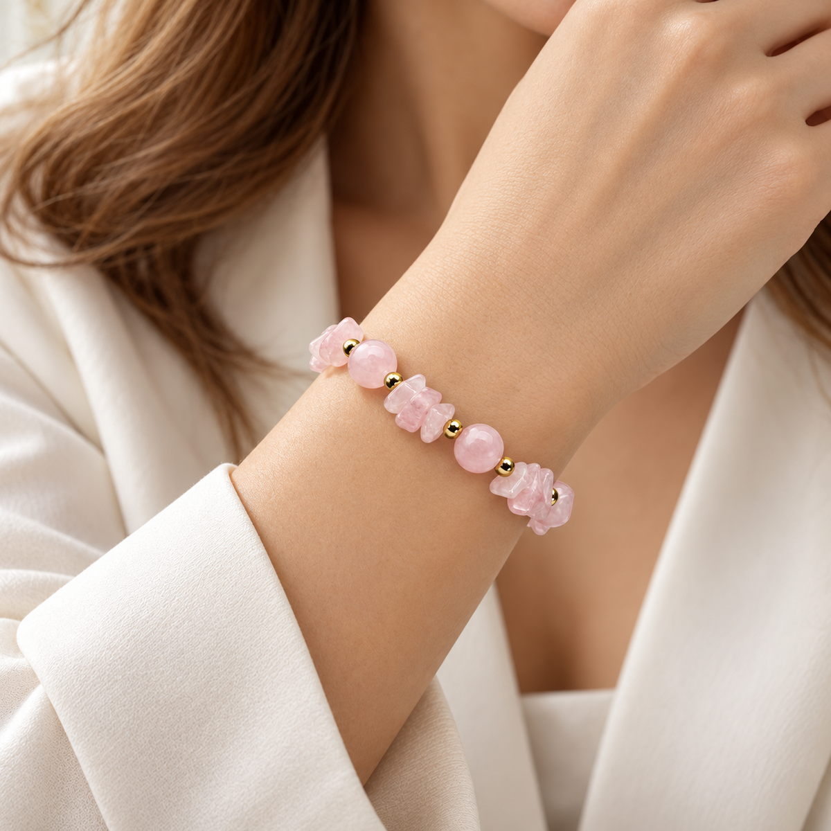 7agat pink Rose Quartz bracelet with irregular chips and gold Hematite worn on a woman's wrist.