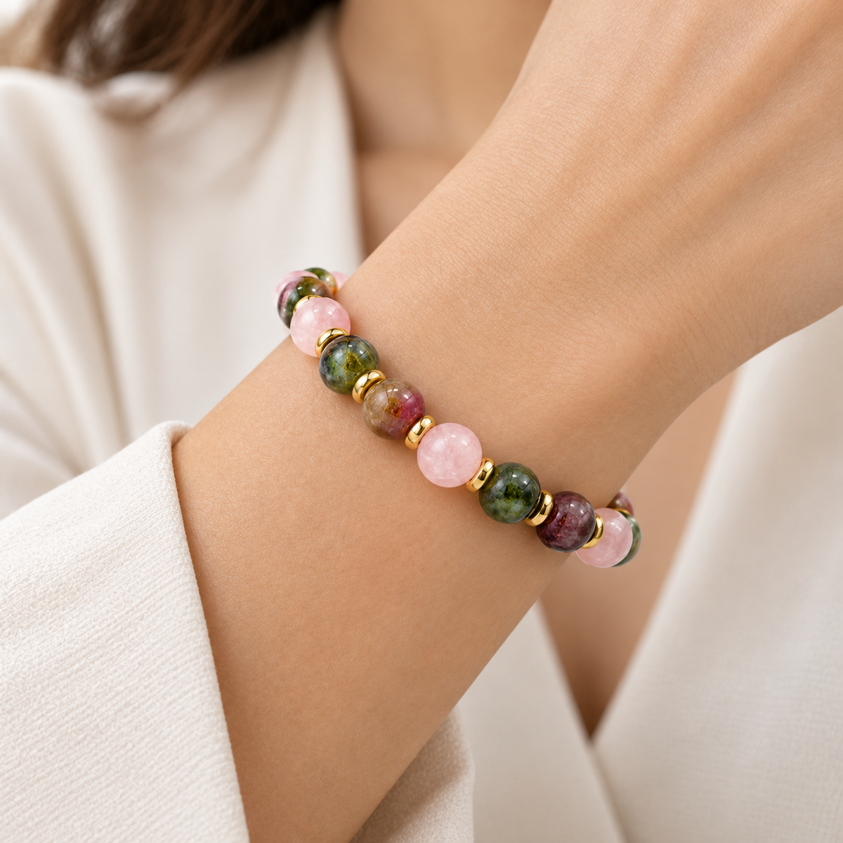 7agat Rose Quartz and Tourmaline 10mm gemstone bracelet worn on a woman's wrist.