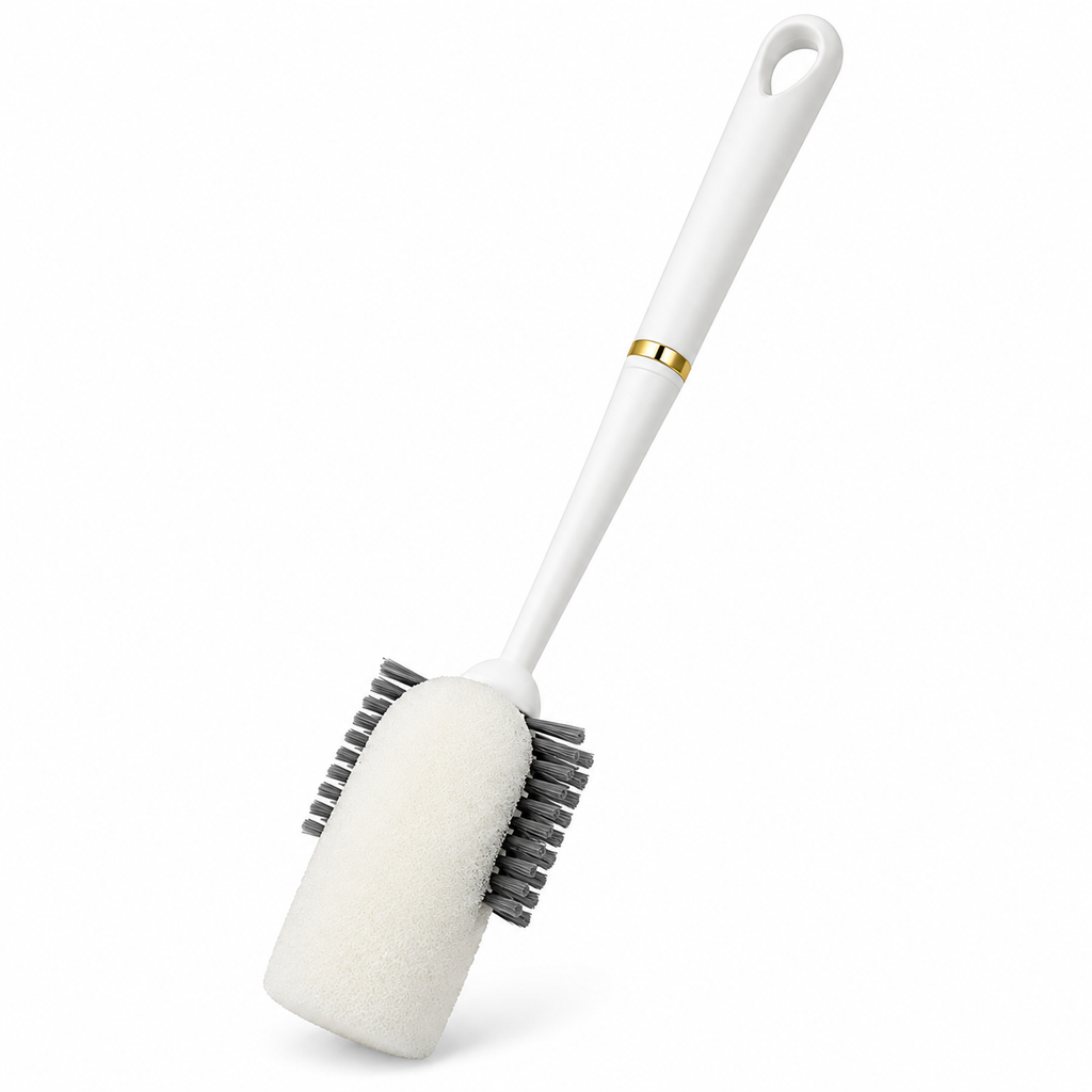 A white cleaning brush with a soft white foam head, dark gray bristles, and a white ergonomic handle accented by a thin gold band, shown on a solid white background.